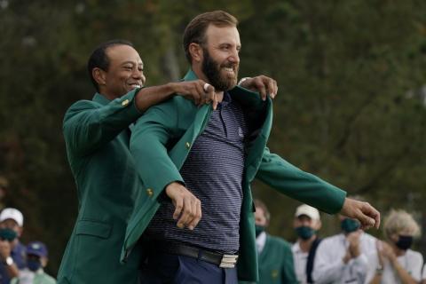Tiger Woods helps Masters' champion Dustin Johnson with his green jacket after his victory at the Masters on Sunday in Augusta, Ga. (AP Photo/CHARLIE RIEDEL/Associated Press)