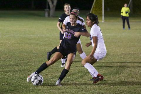 Columbia’s Skyler Ziegaus corrals possession from Suwannee’s Daisy De La Cruz on Thursday night. (BRENT KUYKENDALL/Lake City Reporter)