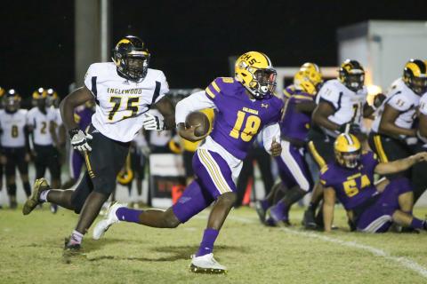 Columbia quarterback Marcus Peterson scrambles past Englewood defensive lineman Andre Vilsaint on Friday night. (BRENT KUYKENDALL/Lake City Reporter)