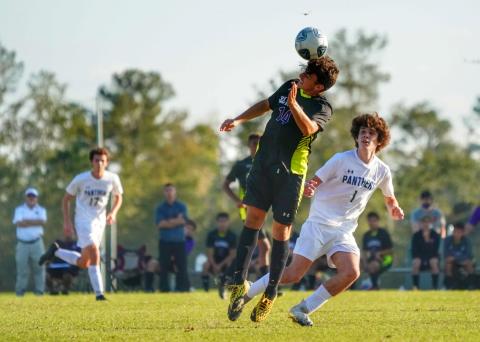 Columbia's john Saucer heads a ball during play against St. John Paul II on Saturday. (BRIAN LEWIS/Special to the Reporter)