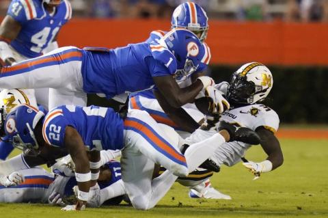 Missouri running back Larry Rountree III, right, is stopped by the Florida defense, including linebacker Brenton Cox Jr. (1) and defensive back Brad Stewart Jr., back, this past Saturday in Gainesville. (JOHN RAOUX/Associated Press)