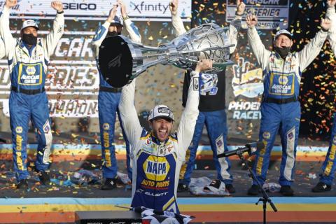 Chase Elliott holds up the season championship trophy as he celebrates with his race crew in Victory Lane after winning a NASCAR Cup Series auto race at Phoenix Raceway on Sunday