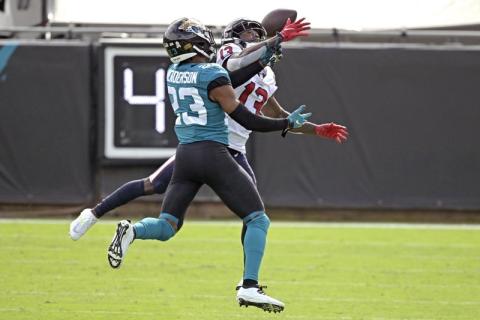 Jacksonville Jaguars cornerback CJ Henderson, left, breaks up a pass intended for Houston Texans wide receiver Brandin Cooks (13) last Sunday in Jacksonville. (PHELAN M. EBENHACK/Associated Press)