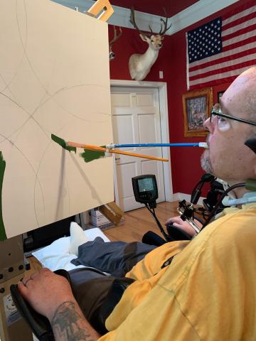 Peter Herrick, a tetraplegic combat veteran from Fort White, paints using a modified paintbursh and a rotating easel. He is the November featured artist at the Gateway Art Gallery. (COURTESY)