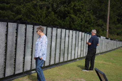 Nancy Chauncey and her husband Stanley Chauncey, of Lake City, look at names on the Vietnam Traveling Memorial Wall Thursday afternoon. The wall will be on display next door to the Honda of Lake City through Tuesday. (TONY BRITT/Lake City Reporter)