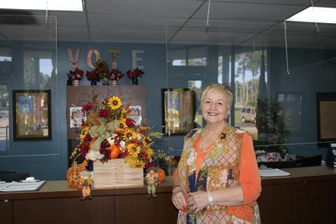 Liz P. Horne, the Columbia County supervisor of elections, stands at the elections office desk. Horne, who has worked at the office for more than 20 years, will retire on Dec. 31. (TONY BRITT/Lake City Reporter)