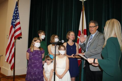 Lineah Sampson and Matilda Sampson (from row from left) stand with Lola Sampson (back row from left) Hannah Sampson, Aubree Sampson and Laura Sampson as Todd Sampson recites his oath of office Monday night. (TONY BRITT/Lake City Reporter)