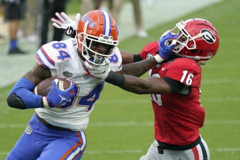 Florida tight end Kyle Pitts (84) tries to get past Georgia defensive back Lewis Cine (16) after a reception on Saturday in Jacksonville. (JOHN RAOUX/Associated Press)