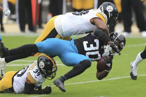 Jacksonville Jaguars running back James Robinson (30) is brought down by Pittsburgh Steelers linebacker Vince Williams, top, and safety Minkah Fitzpatrick (39) on Nov. 22 in Jacksonville. (MATT STAMEY/Associated Press)