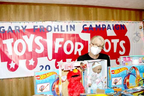 Inga Dwyer, Toys for Tots coordinator for Columbia and Suwannee counties, stands behind a row of toys in her office on Wednesday. (TONY BRITT/Lake City Reporter)