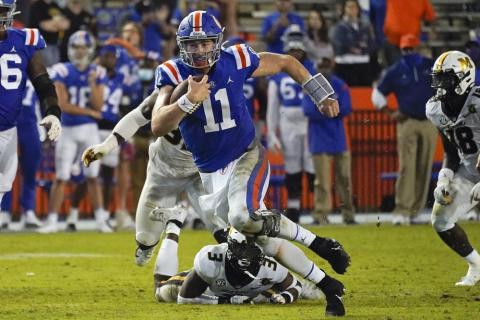 Florida quarterback Kyle Trask (11) runs past Missouri's Martez Manuel (3) and linebacker Nick Bolton, back left, this past Saturday in Gainesville. (JOHN RAOUX/Associated Press)