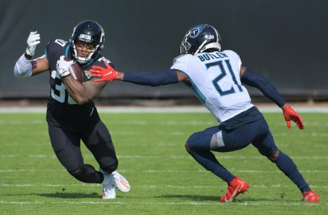 Jacksonville Jaguars running back James Robinson (30) eludes Tennessee Titans cornerback Malcolm Butler (21) during first quarter action at TIAA Bank Field on Sunday in Jacksonville. BOB SELF/TNS)