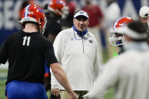 Florida head coach Dan Mullen speaks with players before the first half of the Southeastern Conference championship game between Florida and Alabama on Dec. 19 in Atlanta. (JOHN BAZEMORE/Associated Press)