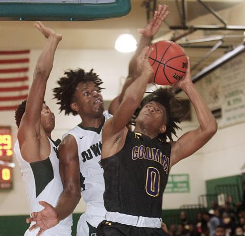 Columbia guard Dante Brown goes up for a shot as Suwannee forward Anthony Brown defends on Saturday night. (PAUL BUCHANAN/Special to the Reporter)