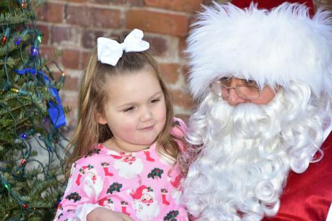 Santa Claus listens to a girl’s wish list Saturday at the 36th annual Christmas on the Square in Live Oak. (ROB WOLFE/Special to the Reporter)