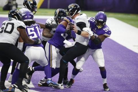 Jacksonville Jaguars quarterback Mike Glennon (center) is tackled for a safety by Minnesota Vikings defensive end Ifeadi Odenigbo, right, on Sunday in Minneapolis. (BRUCE KLUCKHOHN/Associated Press)