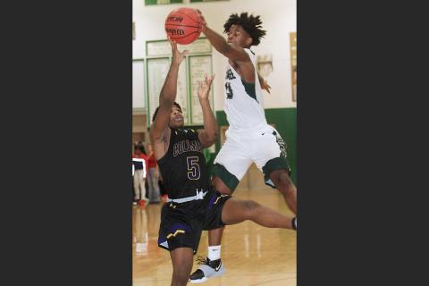 Suwannee forward Anthony Brown blocks Columbia guard Daniel Anderson’s shot during Saturday’s game. The Bulldogs defeated the Tigers 65-58. (PAUL BUCHANAN/Special to the Reporter)