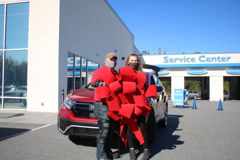 Veteran Jesse Todd, a retired U.S. Army Staff Sergeant who was wounded in Afghanistan, stands with his wife Julia Todd, as the two hold a red ribbon in front of their new 2020 Honda CR-V. Todd, the recipient of a Purple Heart, was given the payment-free vehicle through the Military Warriors Support Foundation’s Transportation4Heroes program Tuesday afternoon at Honda of Lake City. (TONY BRITT/Lake City Reporter)