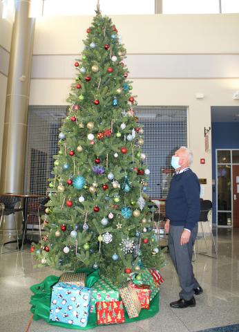 Mike McKee, Florida Gateway College executive director of media/public information, adjusts ornaments on a Christmas tree at the Wilson Rivers Library Wednesday afternoon. FGC will host its inaugural  Winter Wonderland event 5-9 p.m. on Saturday, Dec. 12. (TONY BRITT/Lake City Reporter)