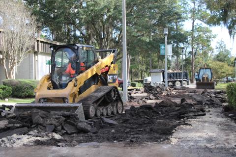 Construction crew workers from Dales Excavation move pieces of asphalt at Florida Gateway College on Thursday afternoon. The asphalt walkways on campus will be demolished during the holiday break and replaced with concrete pavers before students return to classes in January. (TONY BRITT/Lake City Reporter)