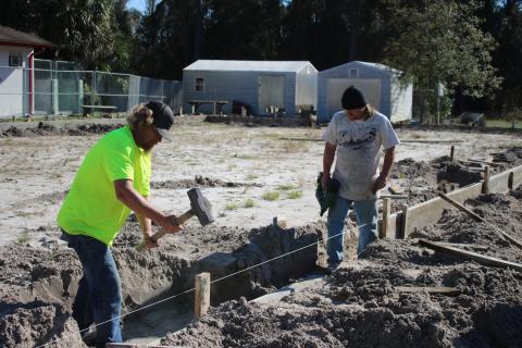 William Glover (left) and Kerry DeYoung put stakes in the ground Wednesday afternoon while doing preparation work for the James Montgomery Animal Wellness Center at the Lake City-Columbia County Humane Society. (TONY BRITT/Lake City Reporter)