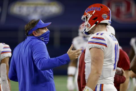 Florida coach Dan Mullen talks with quarterback Kyle Trask after Trask threw a pass into the end zone that was intercepted by Oklahoma's Woodi Washington during the first half of the Cotton Bowl on Wednesday in Arlington, Texas. (RON JENKINS/Associated Press)