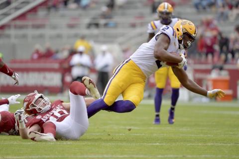 U tight end Arik Gilbert (2) is tripped up by Arkansas defender Bumper Pool (10) in Nov. 21, 2020, in Fayetteville, Ark. (MICHAEL WOODS/Associated Press)