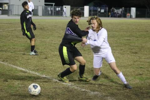 Columbia’s Trey Hingson chases after possession of the ball with Clay’s Ryan Borsheim on Thursday. (JORDAN KROEGER/Lake City Reporter)