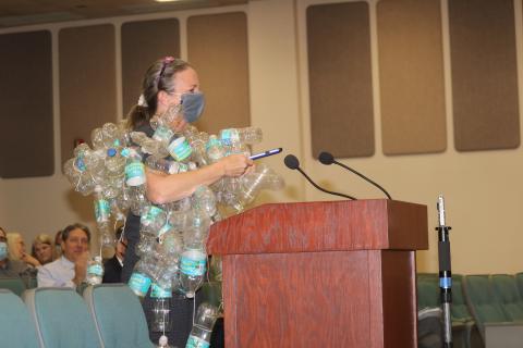 Merrillee Malwitz-Jipson, a Fort White resident, wears a collection of used plastic bottled water containers as she addressed the legislative delegation Tuesday in the Columbia County School Board Administrative Complex Auditorium. Malwitz-Jipson said she wore the bottles to show legislators an example of waste, noting the water bottles will pollute the environment for years. (TONY BRITT/Lake City Reporter)