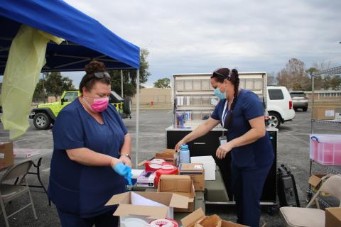 Sarah White (left) and Sara Driggers, Columbia County Health Department nurses, pack up vaccination supplies after helping to vaccinate 630 residents with the covid-19 vaccine on Thursday. The workers vaccinated 630 people in six hours. (TONY BRITT/Lake City Reporter)