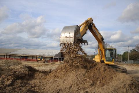 Ken Wells, of Bubba’s Site Prep, uses an excavator to move dirt while prepping a site for the Westside Elementary School multi-purpose room. Construction on the project began last week and is expected to be completed by the end of summer. (TONY BRITT/Lake City Reporter)
