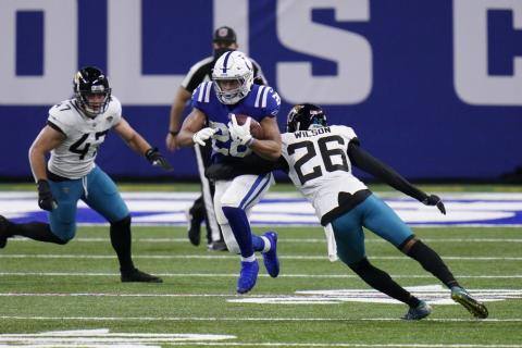 Indianapolis Colts' Jonathan Taylor (28) runs past Jacksonville Jaguars' Jarrod Wilson (26) on Sunday in Indianapolis. (AJ MAST/Associated Press)
