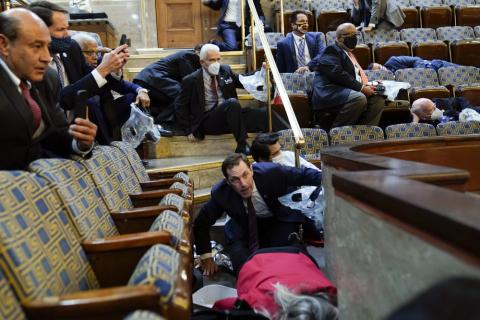 People shelter in the House gallery as protesters try to break into the House Chamber at the U.S. Capitol on Wednesday in Washington. (ANDREW HARNIK/Associated Press)