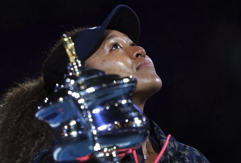 Naomi Osaka holds the Daphne Akhurst Memorial Cup aloft defeating Jennifer Brady in the women's singles final at the Australian Open on Saturday  in Melbourne, Australia. (MARK DADSWELL/Associated Press)