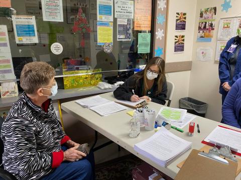 A practical nursing student from Riveroak Technical College assists checking in a patient for their covid-19 vaccine. Students from the college are helping the health departments in Suwannee and Lafayette counties with their vaccine events. (COURTESY)