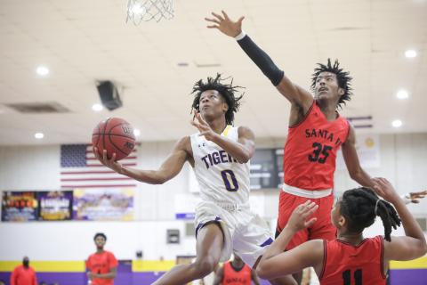 Columbia guard Dante Brown soars past Santa Fe center Jonathan Lee to score a layup on Thursday night. (BRENT KUYKENDALL/Lake City Reporter)