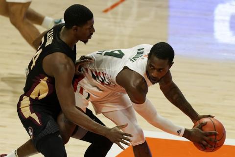 Miami guard Elijah Olaniyi (4) looks to pass the ball as Florida State guard Sardaar Calhoun (24) defends on Wednesday in Coral Gables. (MARTA LAVANDIER/Associated Press)