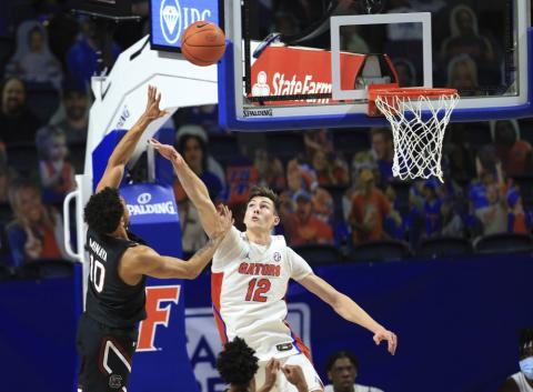 South Carolina forward Justin Minaya (10) makes a shot over Florida forward Colin Castleton (12) during the first half Wednesday in Gainesville. (MATT STAMEY/Associated Press)