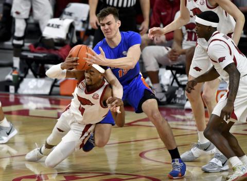 Arkansas guard Jalen Tate (11) and Florida forward Colin Castleton (12) fight for a rebound during Tuesday's game in Fayetteville, Ark.. (MICHAEL WOODS/Associated Press)