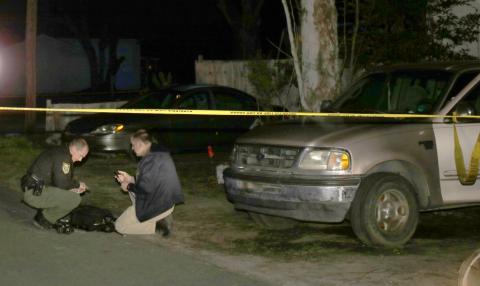 Columbia County Sheriff’s Office investigators search the ground for evidence after deputies found two juveniles shot near the intersection of Southeast Lochlynn and Southeast Putnam Street Tuesday afternoon. No arrests have been made in the case. (TONY BRITT/Lake City Reporter)