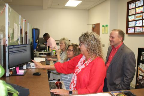 Sherrie Thomas (clockwise from left), Tracy Duckett, and Tammy Hartley, Columbia County Tax Collectors Office employees, show Kyle Keen, Columbia County tax collector, information on the new ORION software Tuesday afternoon. The tax collectors office will be closed Monday while employees take a day of in-service training to learn the new system. (TONY BRITT/Lake City Reporter)