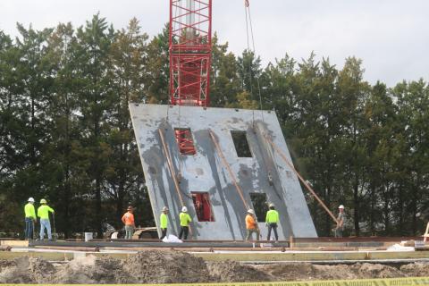 Construction crews lift a wall for the new two-story Belmont Academy building on Tuesday. The walls were being erected Tuesday and Wednesday with the facility expected to open this fall. (TONY BRITT/Lake City Reporter)