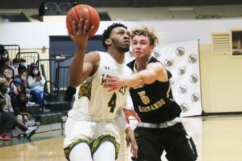 FGC guard Antonio Card rises on the fast break to score as PHSC guard Hayden Greene gives chase on Thursday night at the Howard Center. (JORDAN KROEGER/Lake City Reporter)