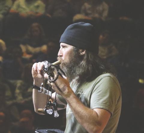 Jason Silas “Jase” Robertson, one of the stars on the show ‘Duck Dynasty,’ demonstrates one of his duck calls Thursday night at the Christ Central church. (MORGAN MCMULLEN/Lake City Reporter)