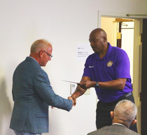Gary Wilson (from left) receives a thank-you note and handshake from Columbia track & field coach Lawrence Davis during Thursday’s meeting. (MORGAN MCMULLEN/Lake City Reporter)