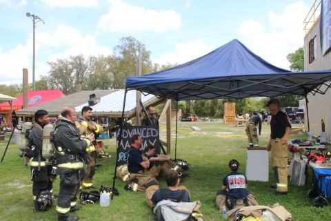 Firefighters adjust their gear as they listen to a Third Alarm Public Safety Training instructor present tips on firefighter survival. (TONY BRITT/Lake City Reporter)