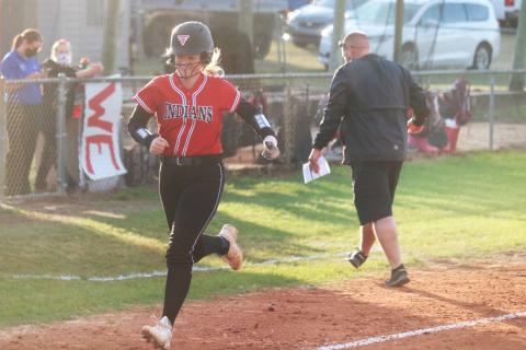 Fort White’s Kadence Compton smiles heading toward home plate after hitting a home run against Bronson while assistant coach Chad Padgett celebrates on Friday night. (JORDAN KROEGER/Lake City Reporter)