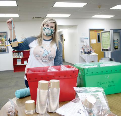 Kate Duong, the youth services librarian for the Columbia County Public Library, shows off the bird feeder students can make in the Backyard Birds kit. (TONY BRITT/Lake City Reporter)