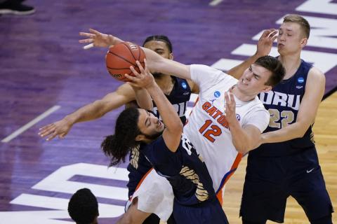 Oral Roberts guard Kareem Thompson, left, grabs a rebound in front of Florida forward Colin Castleton (12) during the second  round of the NCAA Tournament at Indiana Farmers Coliseum on Sunday in Indianapolis. (AJ MAST/Associated Press)