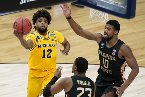 Michigan guard Mike Smith (12) drives to the basket over Florida State guard M.J. Walker (23) and forward Malik Osborne (10) during the second half of a Sweet 16 game in the NCAA Tournament at Bankers Life Fieldhouse on Sunday in Indianapolis. (DARRON CUMMINGS/Associated Press)